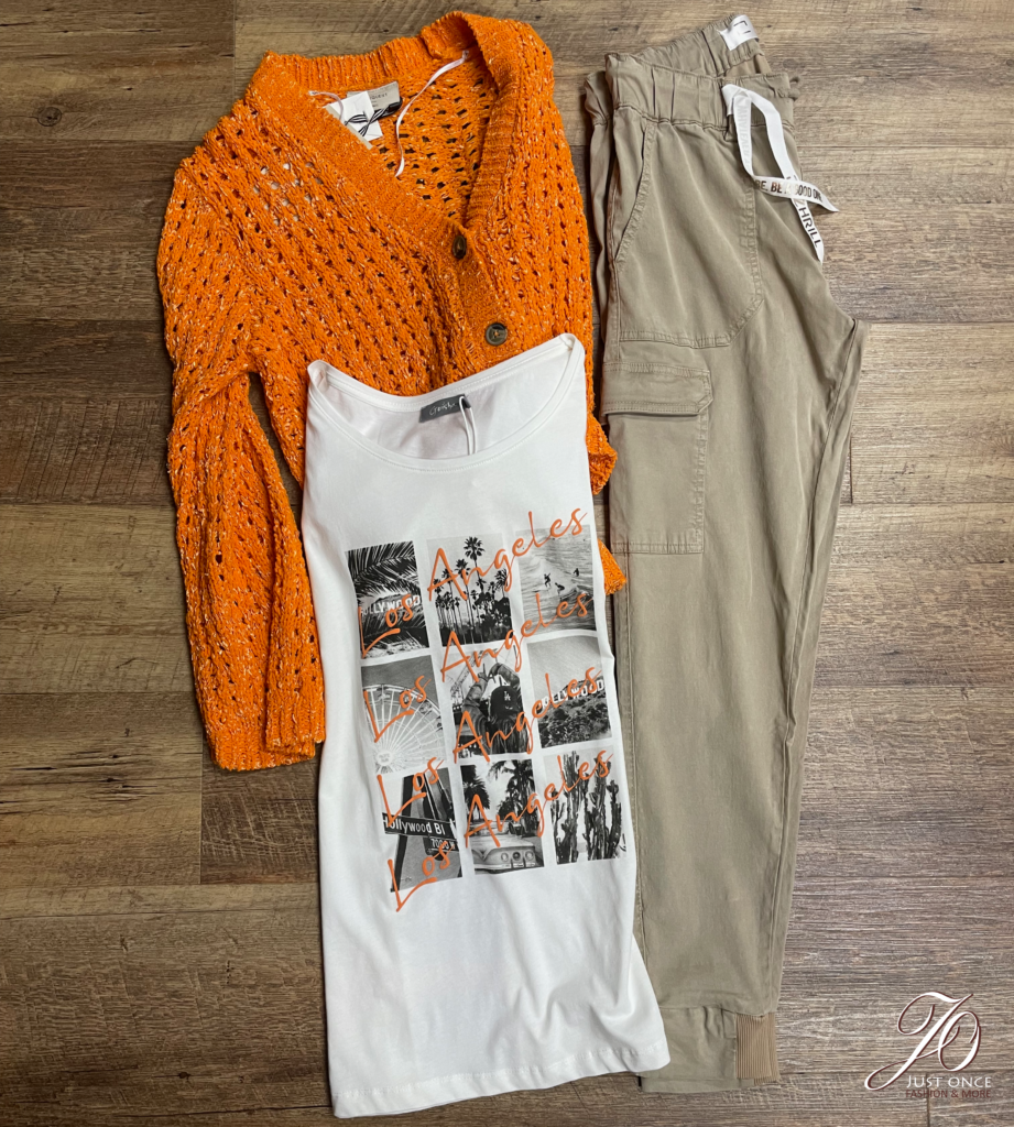 alt="Chinohose mit bedrucktem T-Shirt und orangener Strickjacke, passend zum Herbstanfang"